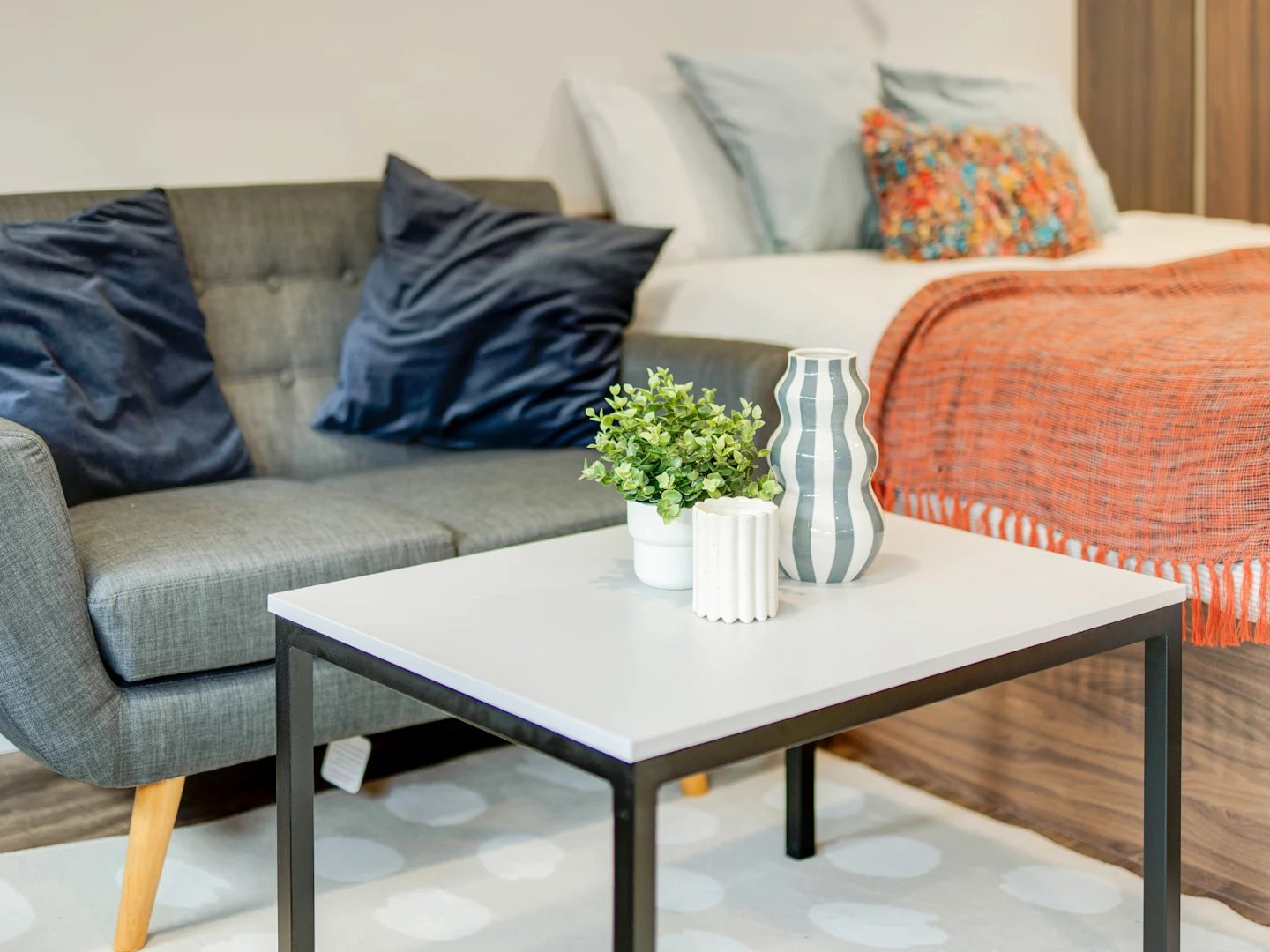 Grey sofa navy pillows bed orange throw living room at Stanley Studios - Dundee in Dundee Student Accommodation