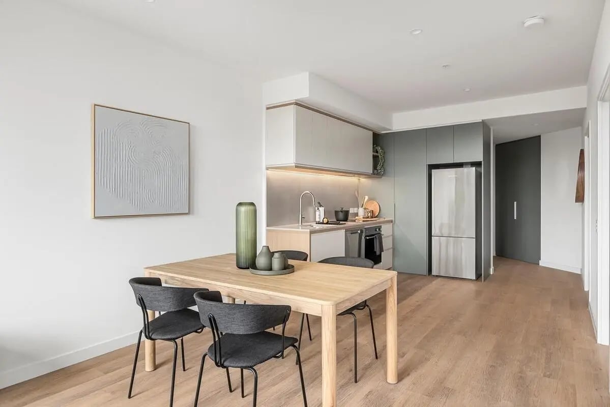 Dining table chairs artwork kitchen and refrigerator living area at Caulfield Place in Melbourne Student Accommodation