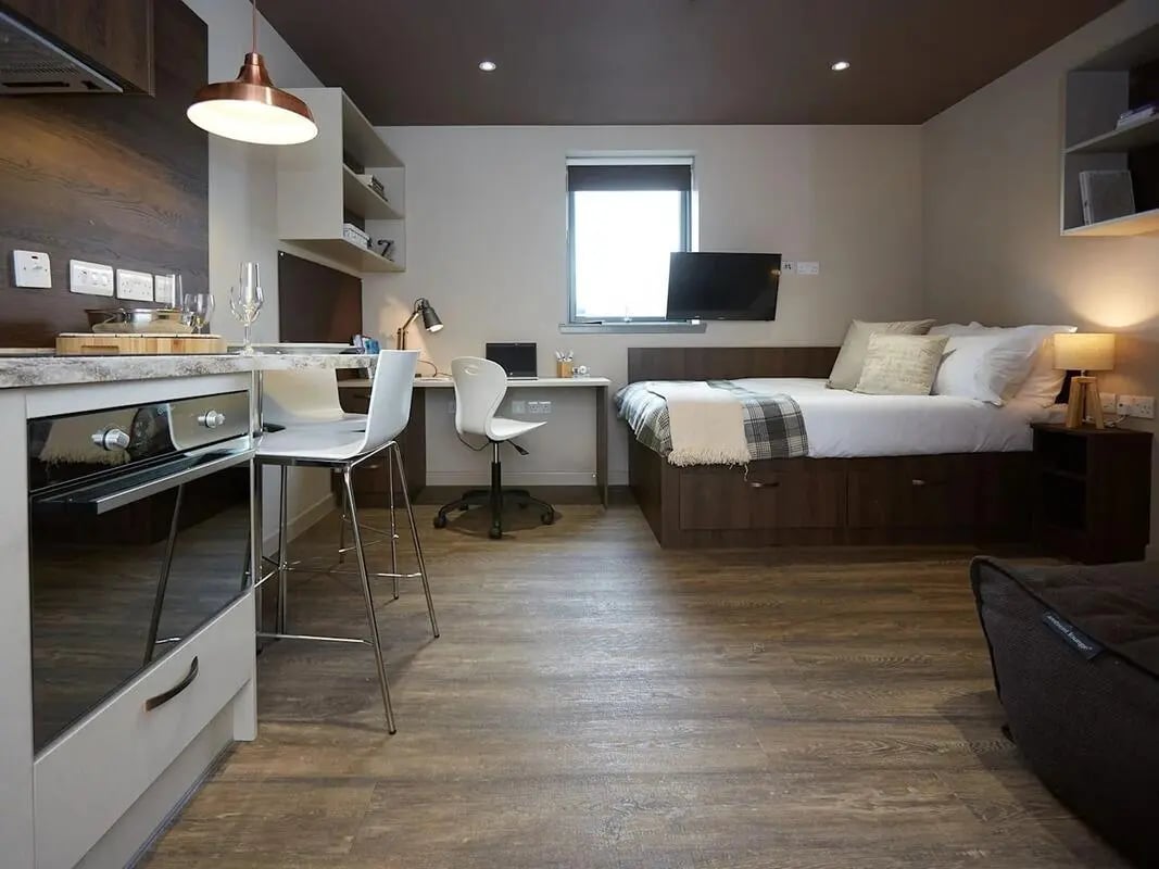 Bed desk kitchen and chairs studio apartment at Woodside House in Glasgow Student Accommodation