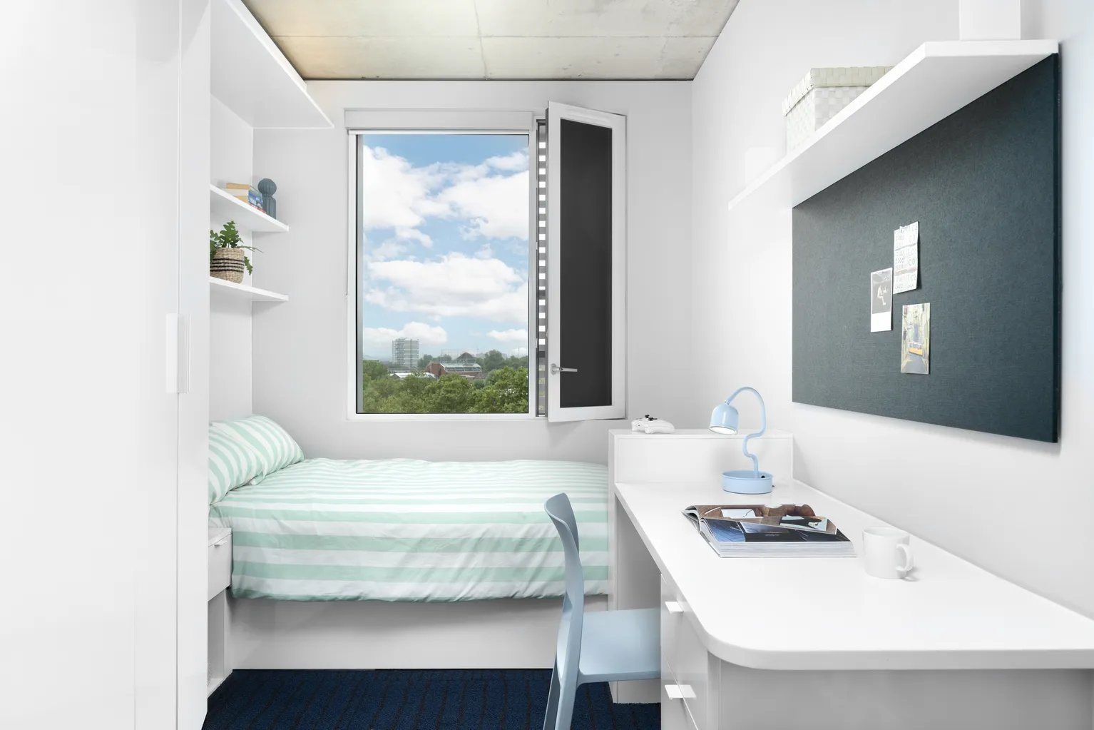 Bed desk chair lamp and bulletin board bedroom at Scape Canada Water in London Student Accommodation