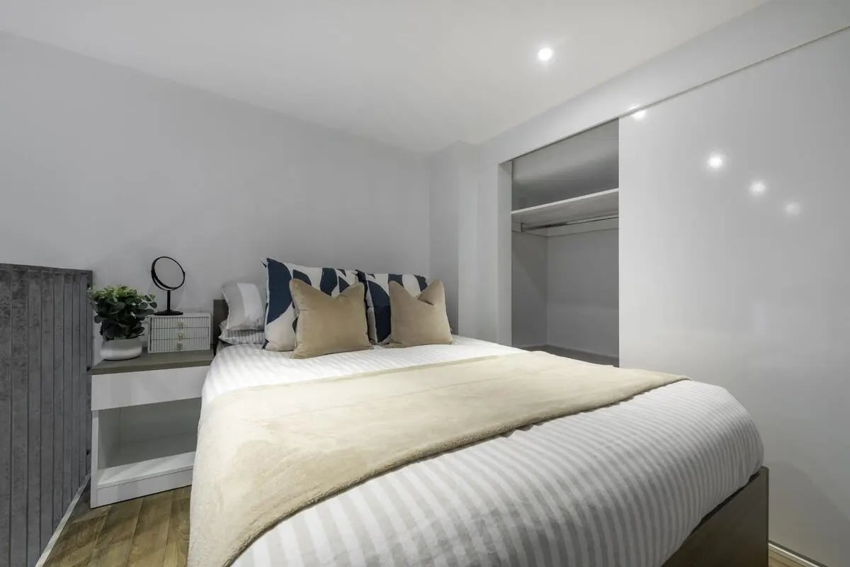 Bed with decorative pillows nightstand and closet bedroom at Stepney Yard in Newcastle Upon Tyne Student Accommodation