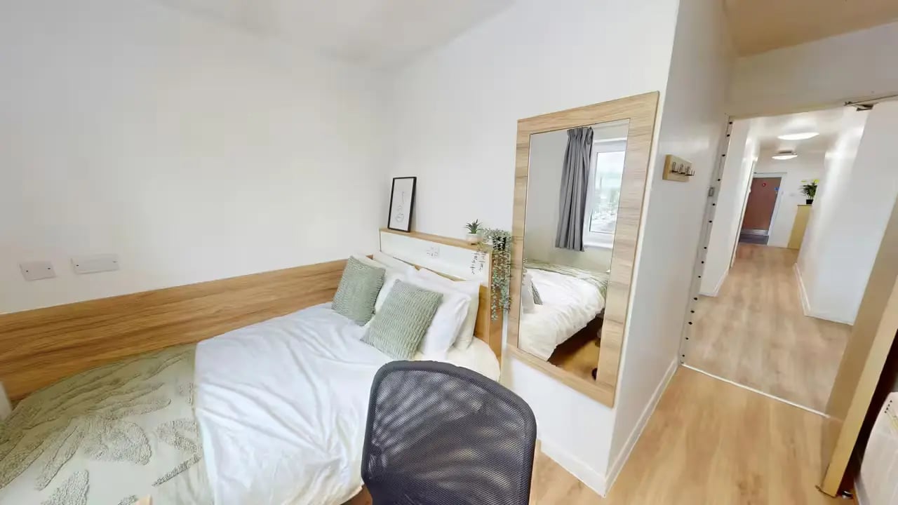 Bed with pillows mirror and hallway bedroom at MSV South in Manchester Student Accommodation