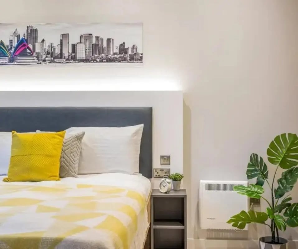 Bed with yellow blanket grey headboard artwork bedroom at Gravity in Lincoln Student Accommodation