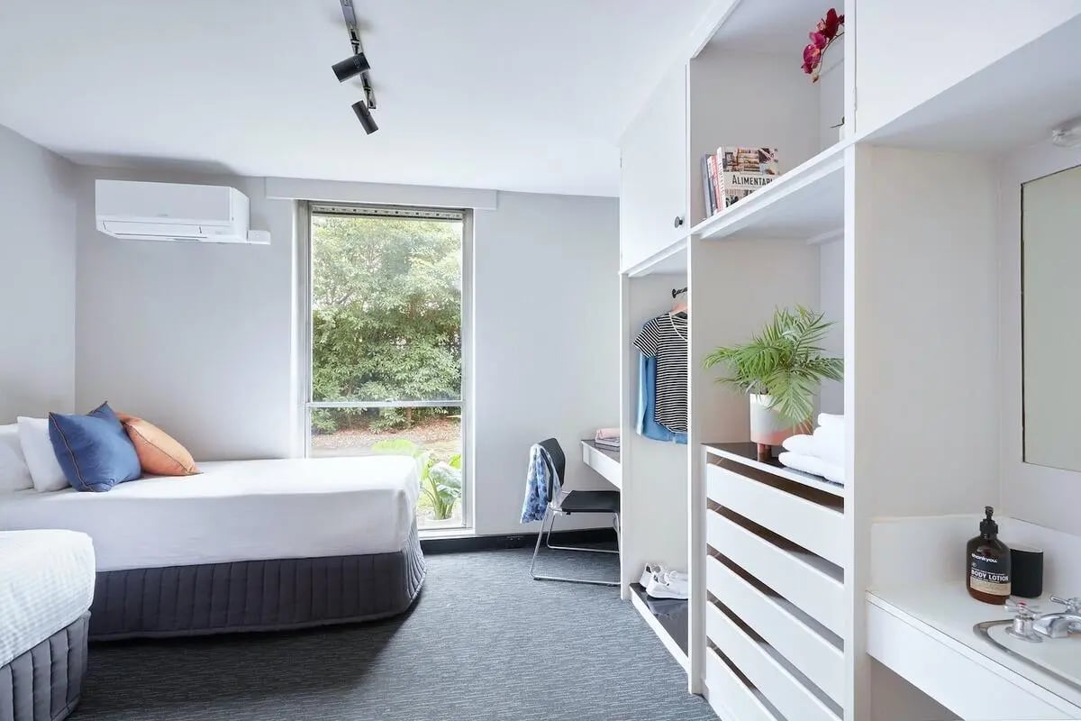 Two beds with pillows desk closet study bedroom at Campus Melbourne in Melbourne Student Accommodation