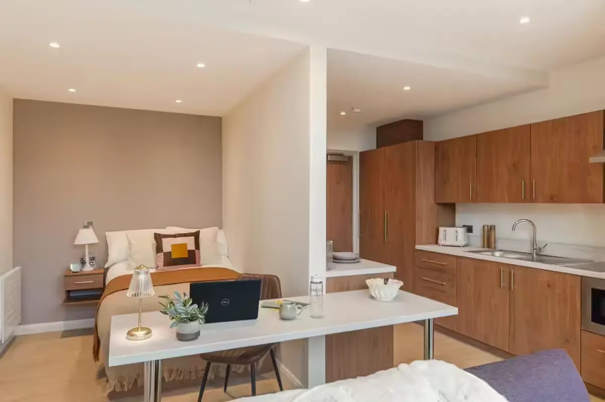 Bed kitchen desk and laptop studio apartment at Ryan Hall in Belfast Student Accommodation