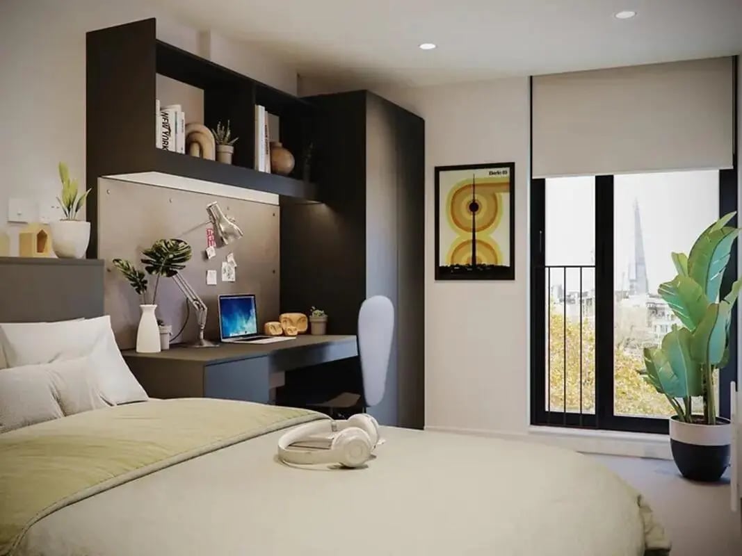 Bed desk laptop headphones plants framed art bedroom at Element Bermondsey in London Student Accommodation