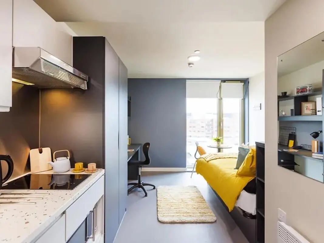 Kitchen and bedroom with bed and desk Studio apartment at Element Manchester in Manchester Student Accommodation