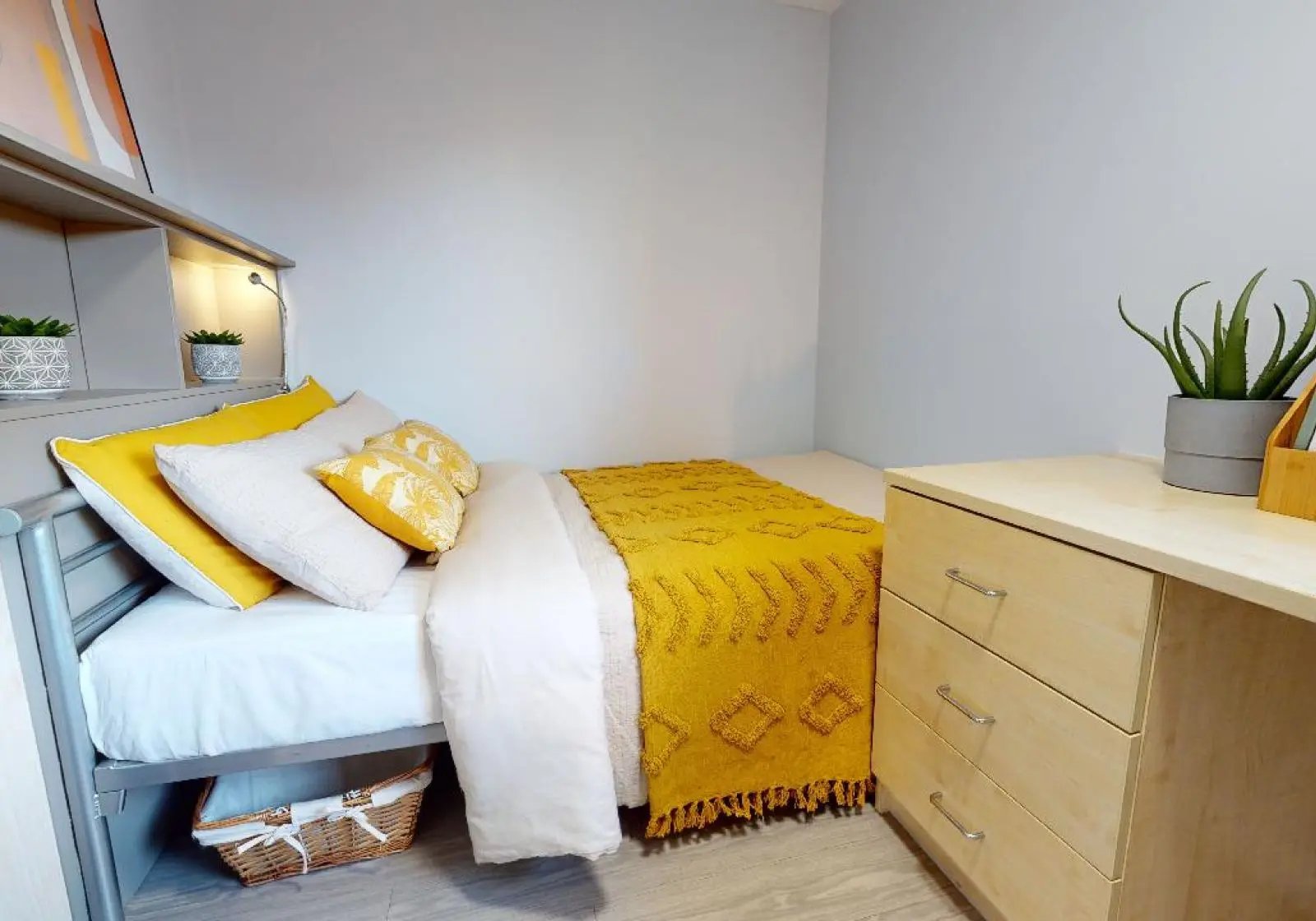 Bed pillows yellow blanket dresser plant bedroom at iQ Brocco in Sheffield Student Accommodation