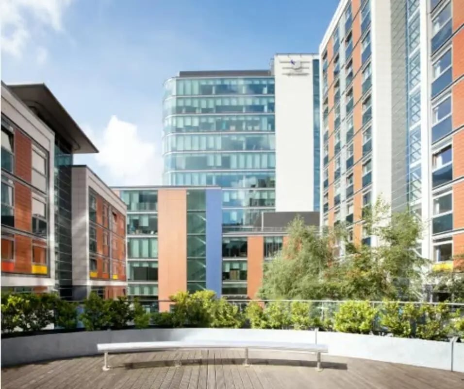 Bench on wooden deck with apartment buildings exterior at The Paragon in London Student Accommodation