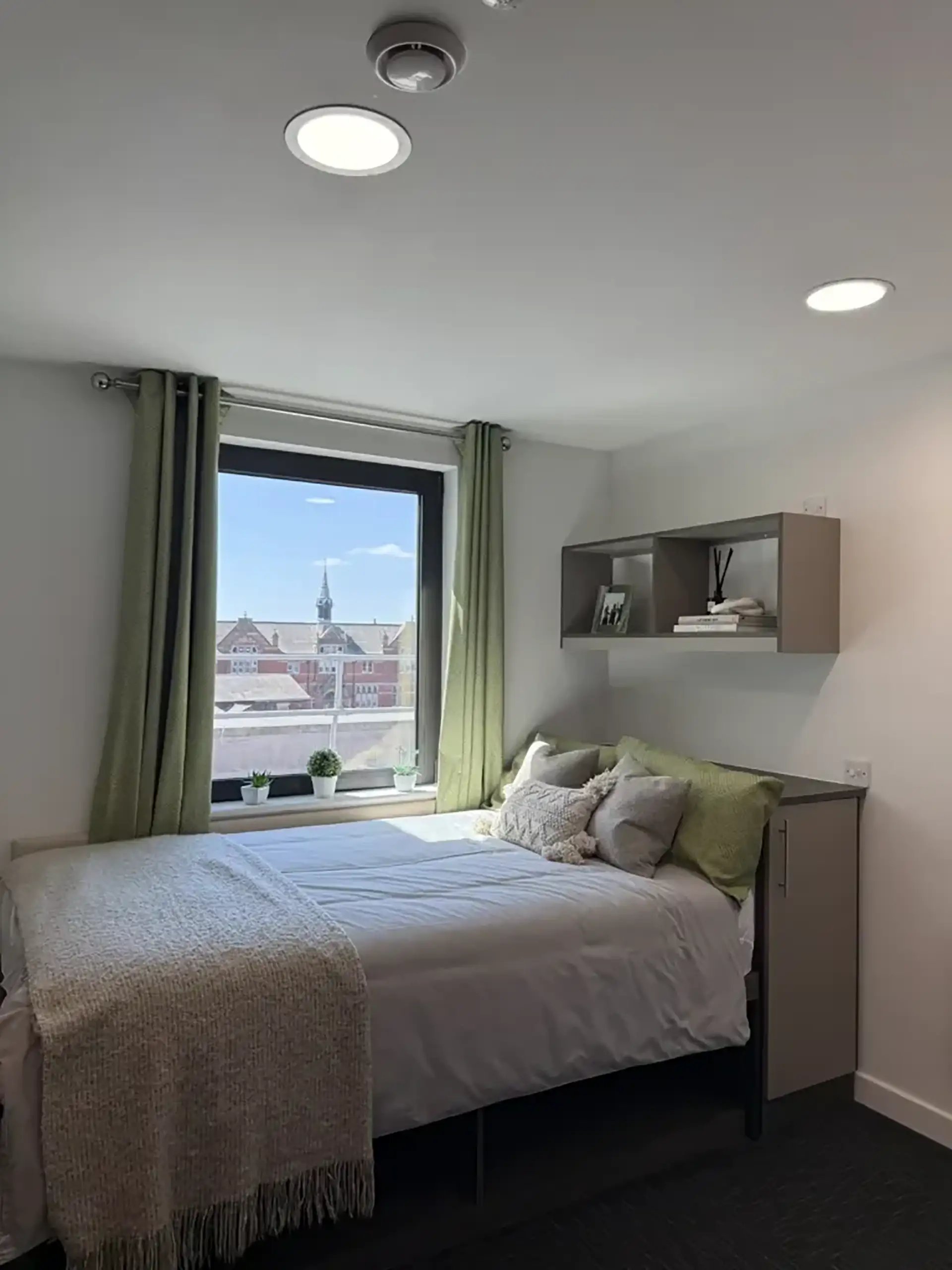 Bed with pillows green curtains and window view bedroom at Friargate Court in Preston Student Accommodation