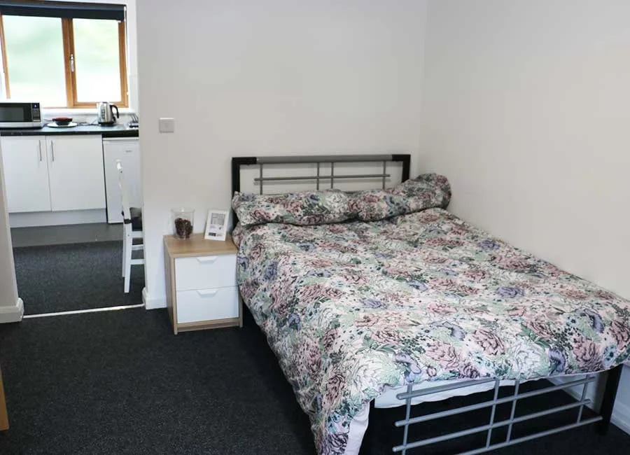 Bed bedside table microwave kettle and cabinets bedroom at Forest Rise in Loughborough Student Accommodation
