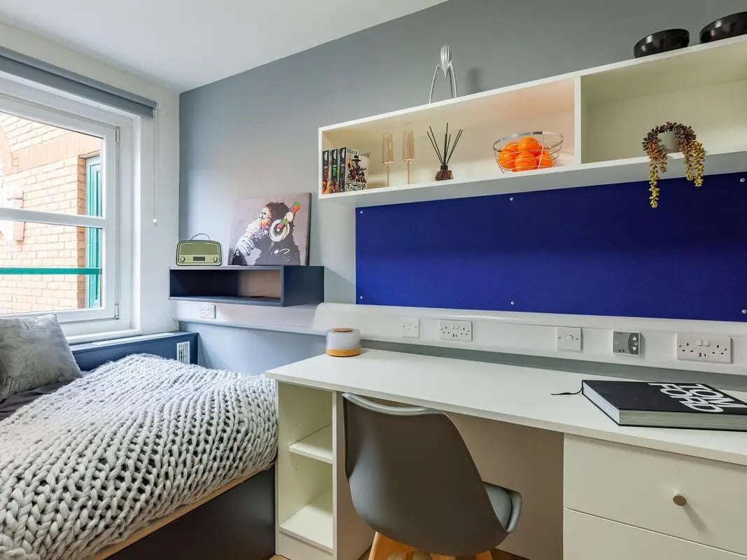 Bed desk shelving with art and fruit bedroom at The Bridge Guildford in Guildford Student Accommodation