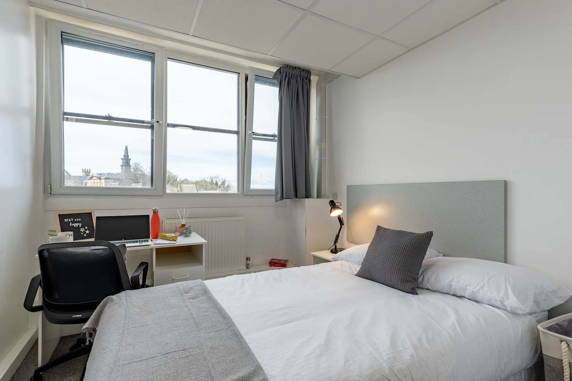 Desk bed lamp laptop water bottle bedroom at MyPad Paisley in Paisley Student Accommodation