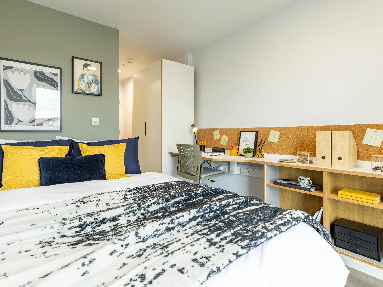 Bed with yellow pillows desk with lamp bedroom at New Bridewell in Bristol Student Accommodation