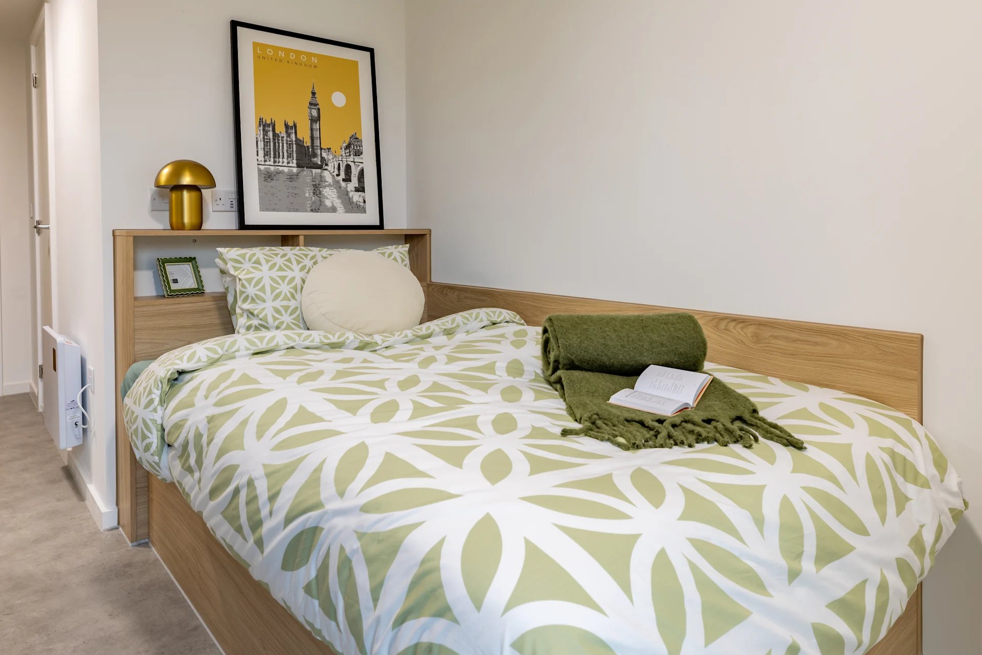 Bed with patterned duvet and green throw Bedroom at Venti House in London Student Accommodation