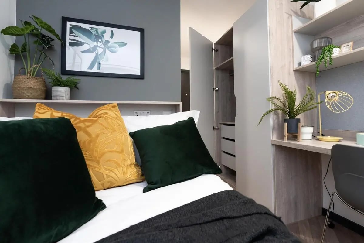 Bed with plants framed picture closet desk bedroom at Steelworks in Sheffield Student Accommodation