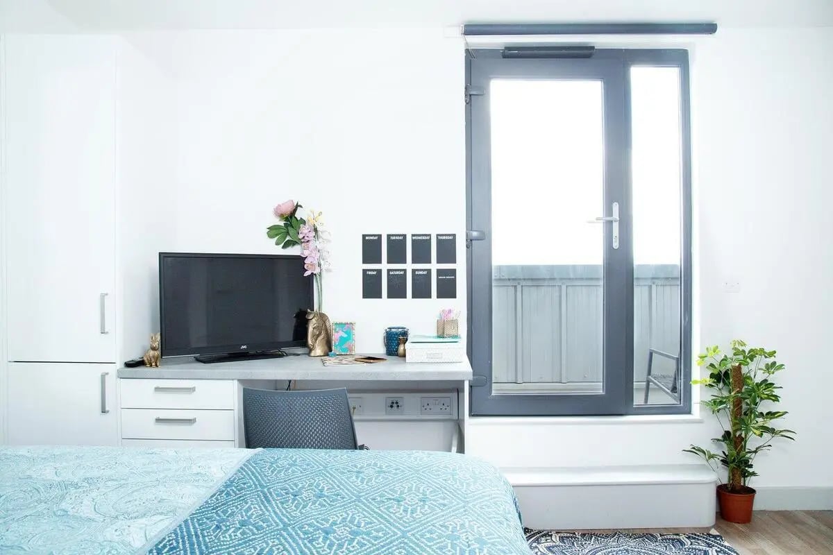Desk with TV and balcony door study area at The Bridge Phase II in Newcastle Upon Tyne Student Accommodation