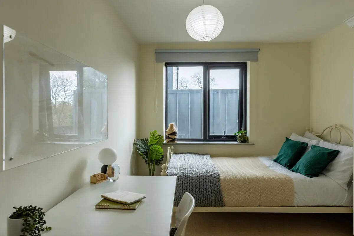 Desk bed with green pillows and plants bedroom at Mary Morris House in Leeds Student Accommodation
