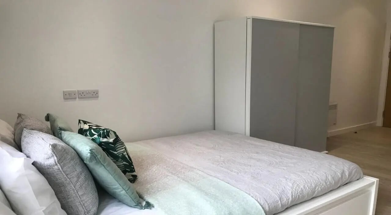 Bed with pillows wardrobe and sockets bedroom at Orme House in Newcastle Under Lyme Student Accommodation