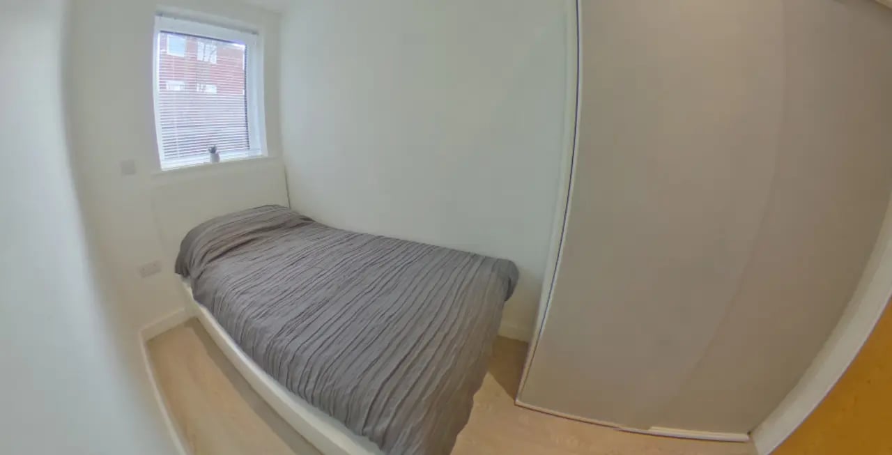 Single bed grey duvet window wardrobe bedroom at Orme House in Newcastle Under Lyme Student Accommodation