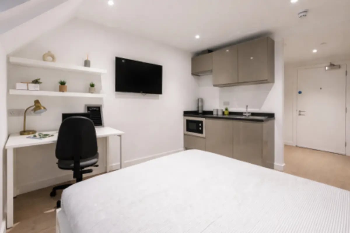 Bed desk kitchen and door studio apartment at Sizer Court in Preston Student Accommodation