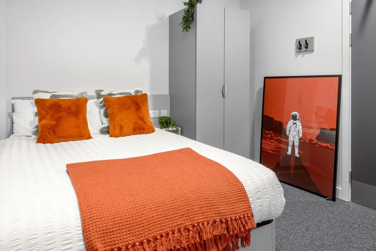 Bed with orange pillows and throw Bedroom at True Leicester in Leicester Student Accommodation