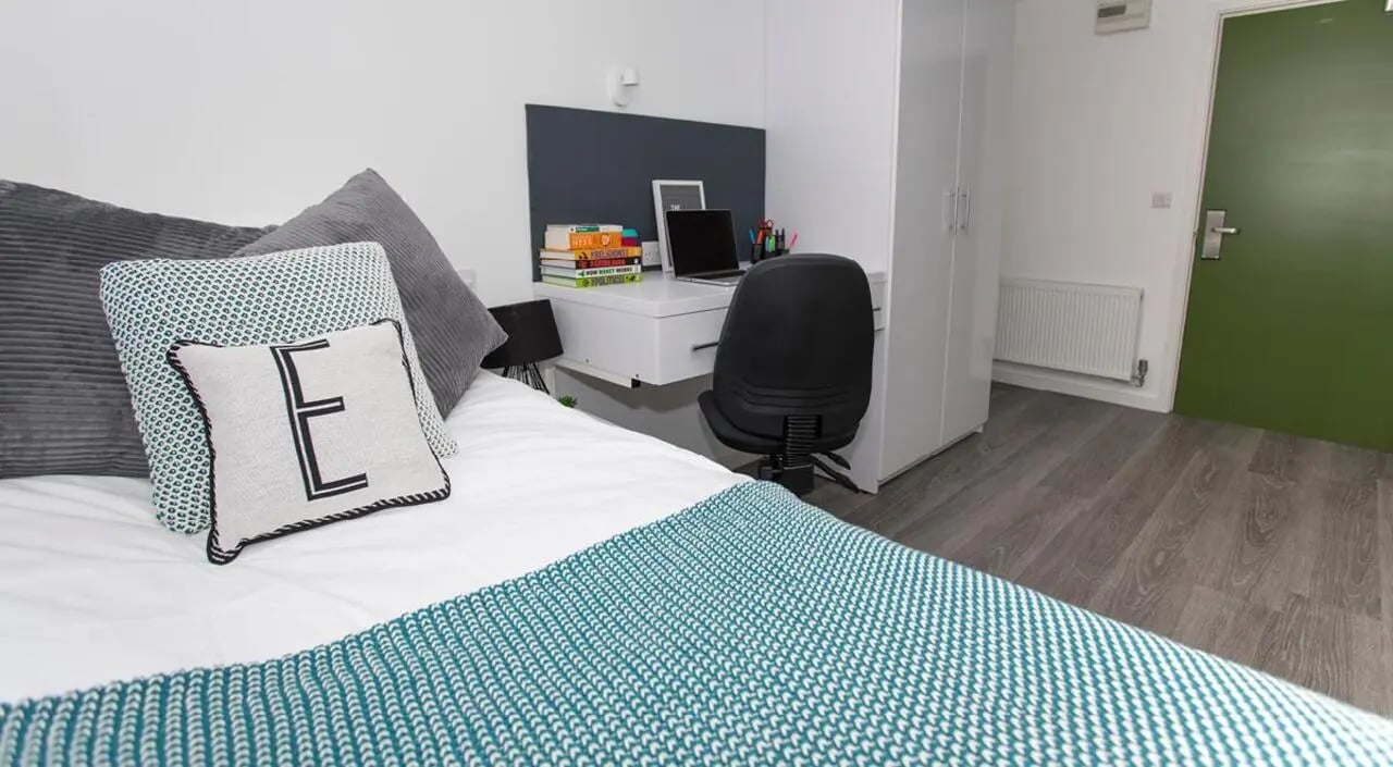 Bed desk chair and pillows bedroom at The Cube Ealing in London Student Accommodation