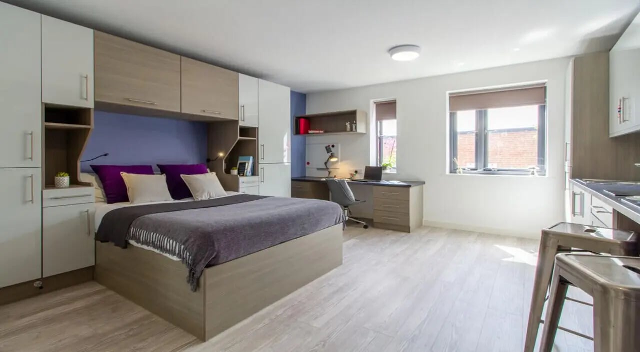 Bed desk chair and kitchen area bedroom at St Giles Studios in Durham Student Accommodation