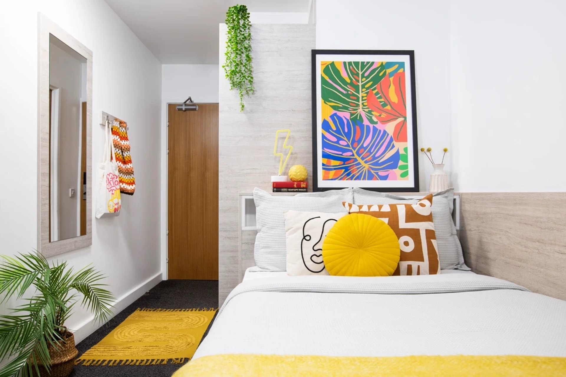 Bed with colorful pillows and tropical art bedroom at The Bakery in Cardiff Student Accommodation