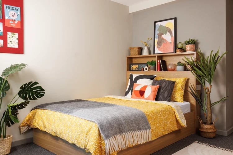 Bed with yellow patterned duvet and grey throw bedroom at Manor Bank in Newcastle Upon Tyne Student Accommodation