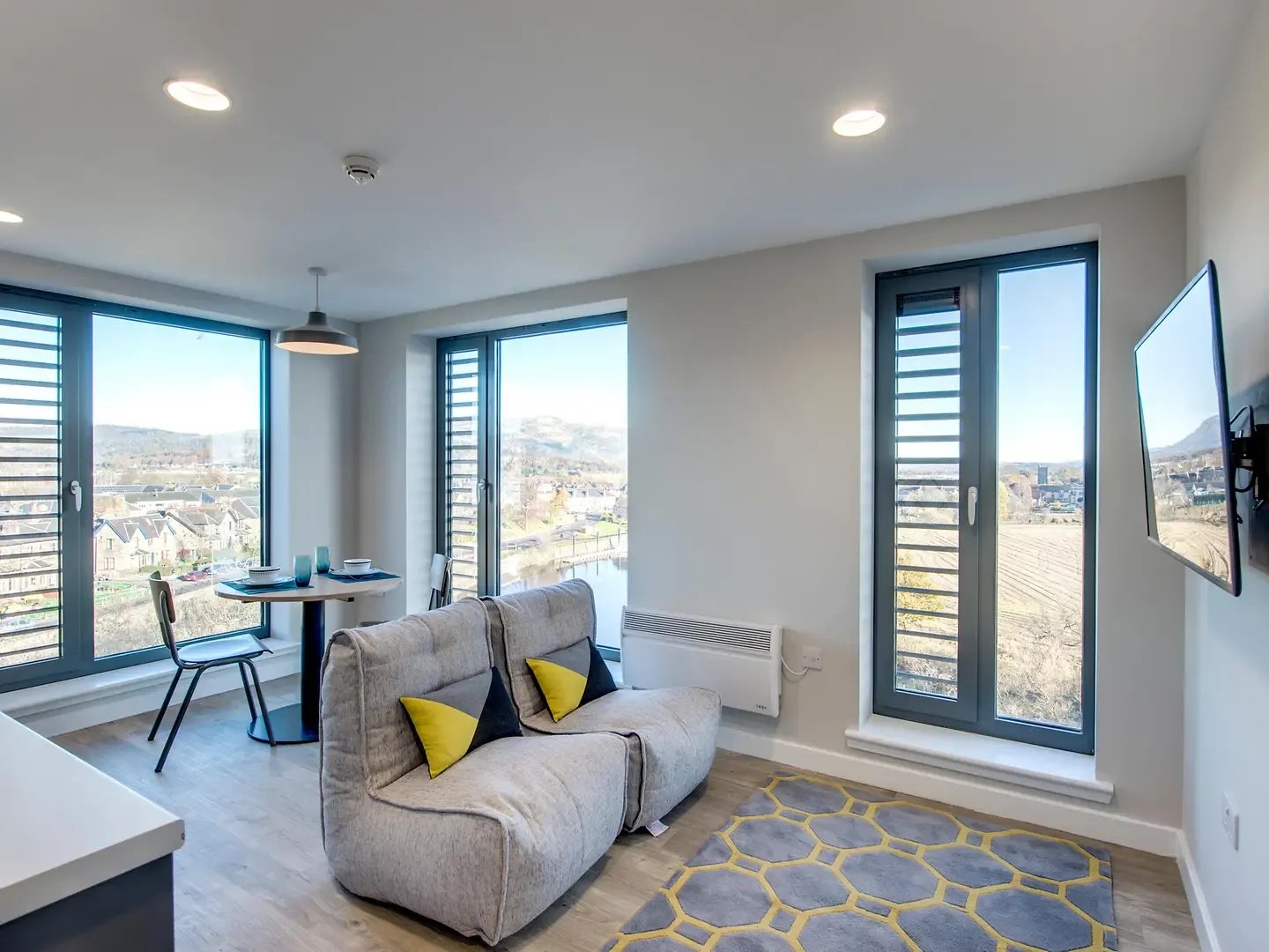 Grey sofa table chairs and television living room at Riverside Quay in Stirling Student Accommodation
