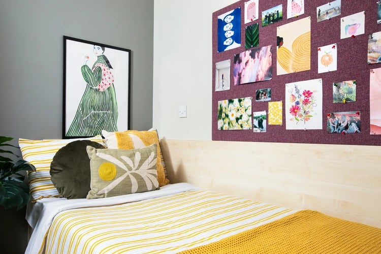 Bed with artwork and pinned photos bedroom at Quantum Court in London Student Accommodation