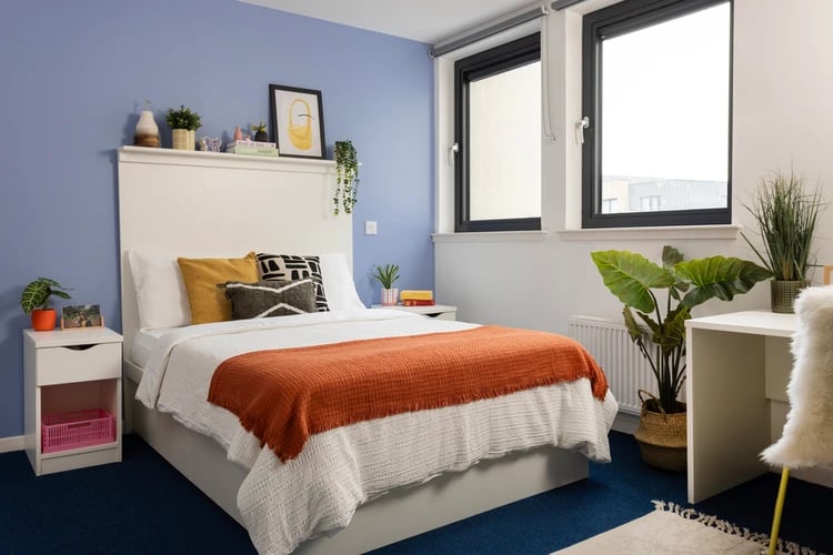 Bed with orange throw nightstand and desk bedroom at Shrubhill House in Edinburgh Student Accommodation