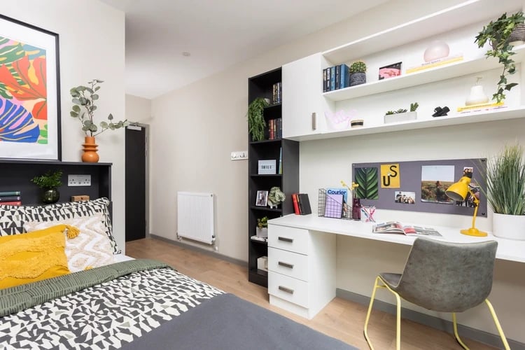Bed desk shelves artwork plants bedroom study area at Arch View House in London Student Accommodation