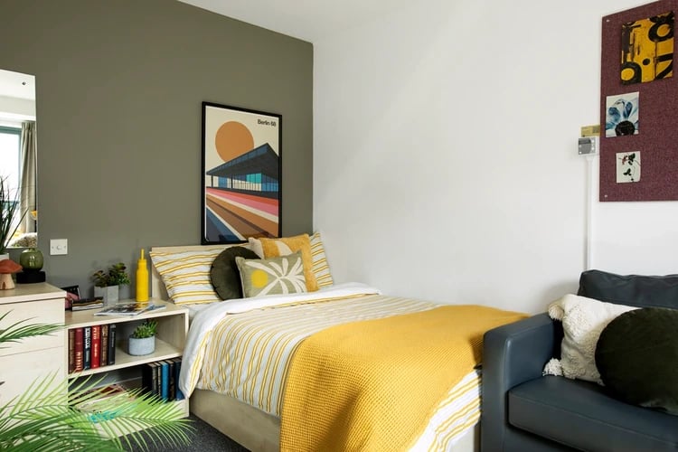 Bed with yellow throw and artwork bedroom at Blithehale Court in London Student Accommodation