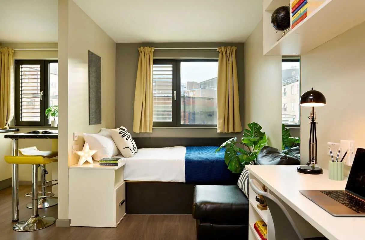 Bed white linens blue blanket desk laptop bedroom at Millennium View in Coventry Student Accommodation