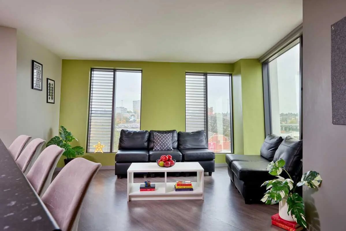 Black sofas white coffee table living room at Millennium View in Coventry Student Accommodation