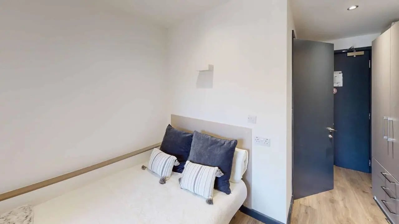 Bed with pillows and wardrobe bedroom at Opto village in Luton Student Accommodation