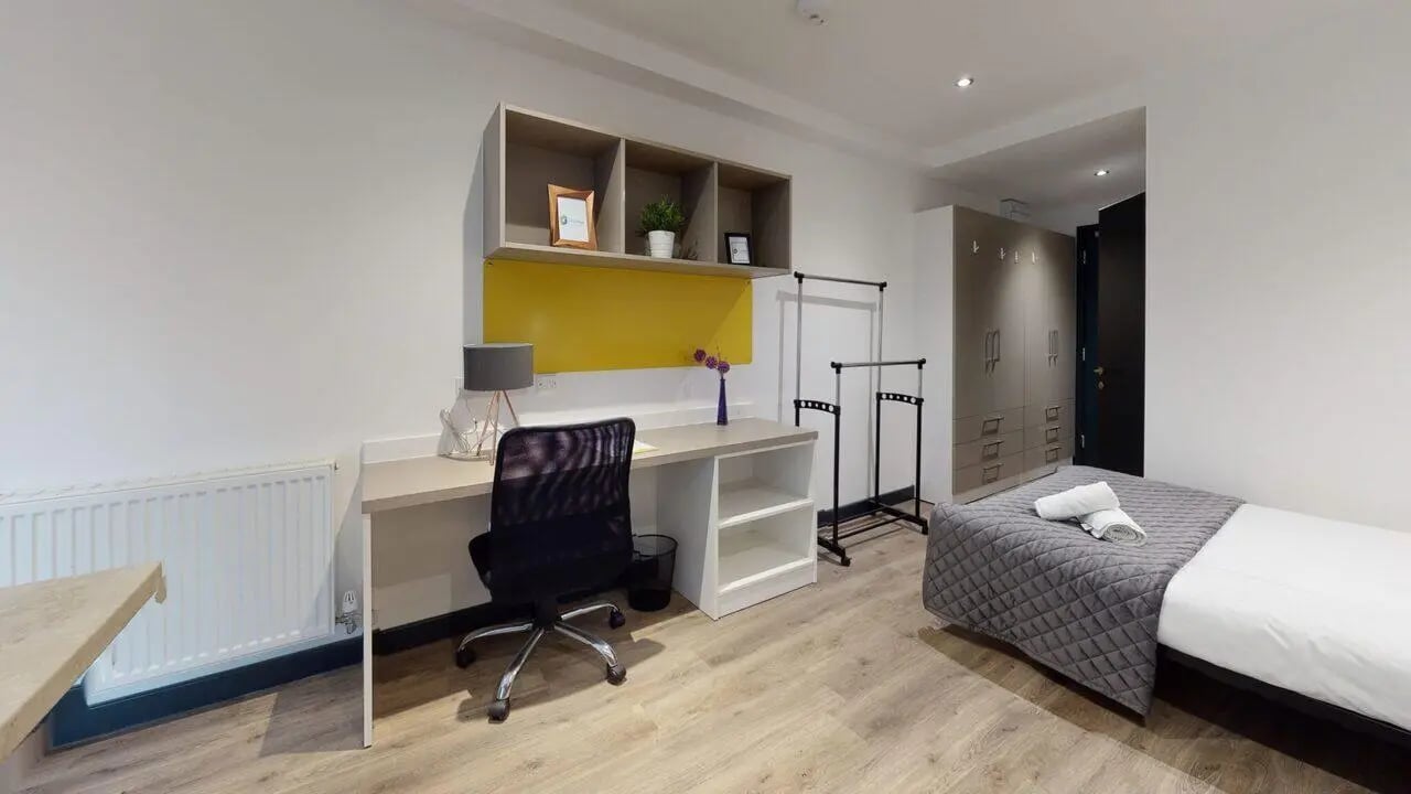 Bed desk chair wardrobe and shelves bedroom at Opto village in Luton Student Accommodation