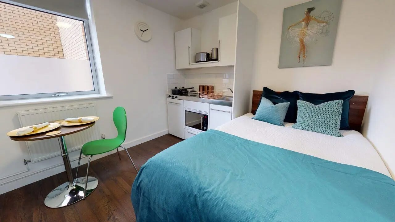 Bed kitchen dining table and chair studio apartment at Park House in Luton Student Accommodation