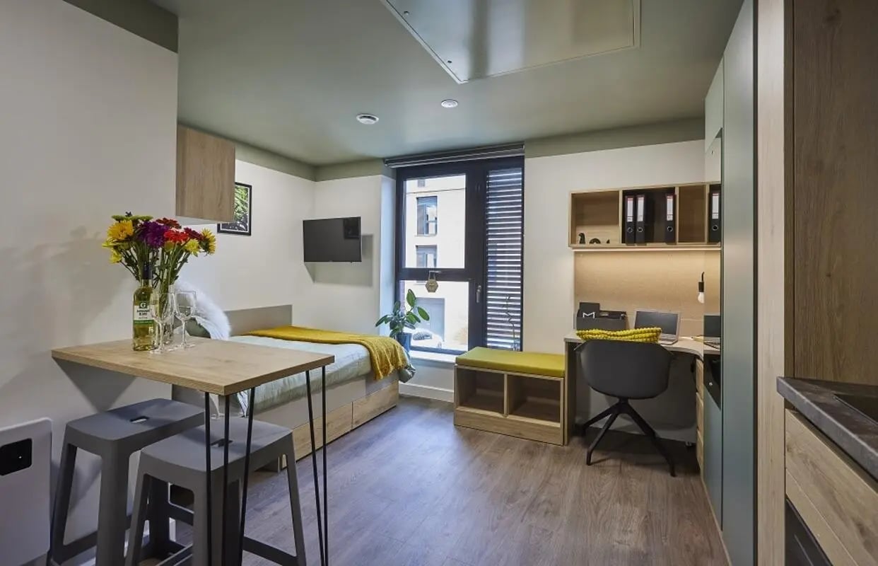 Bed desk and stools in studio apartment bedroom at Regatta Place in Durham Student Accommodation