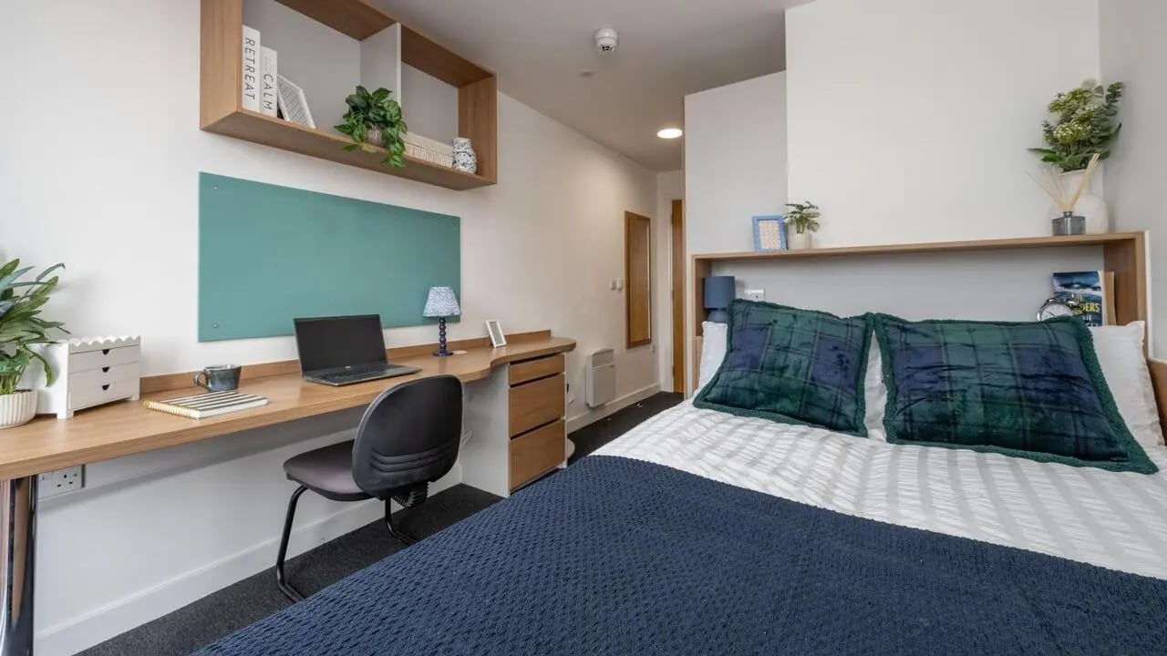 Bed desk shelves laptop chair pillows bedroom at The Elements in Sheffield Student Accommodation