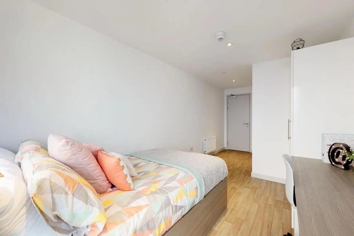 Bed with colorful pillows and blanket bedroom at The Bridge in Newcastle Upon Tyne Student Accommodation
