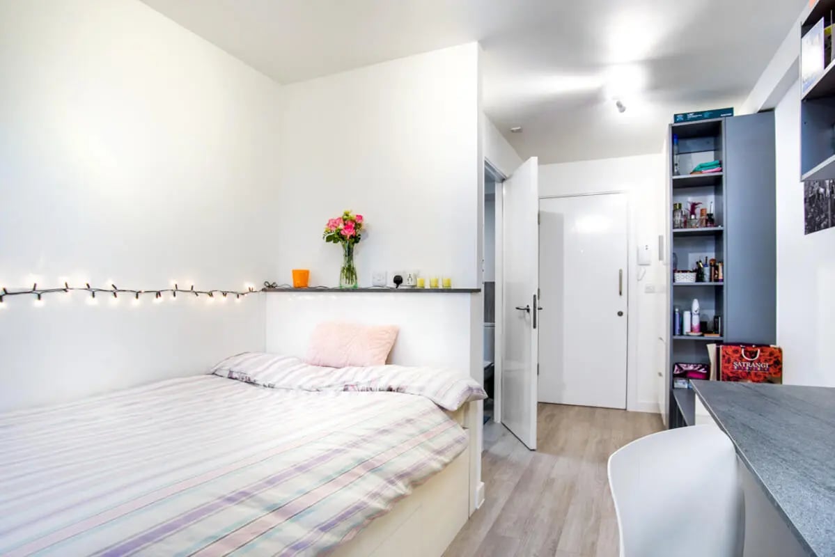 Bed with fairy lights flowers desk and bookshelf bedroom at The Recording Rooms in Birmingham Student Accommodation