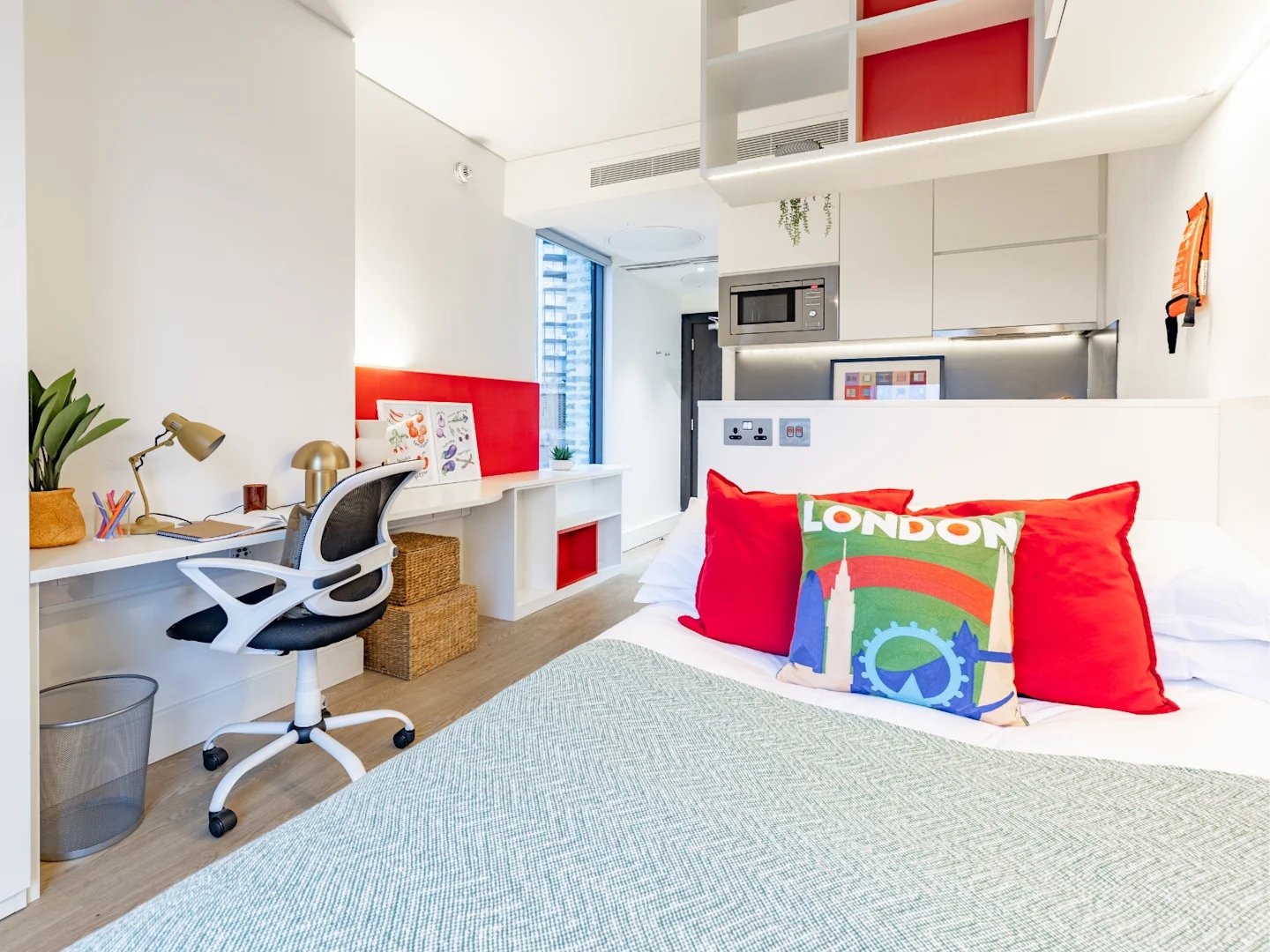 Bed desk chair kitchen area bedroom at Spring Mews in London Student Accommodation