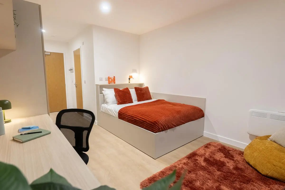 Desk chair bed with orange bedding bedroom at Telephone House in Dundee Student Accommodation
