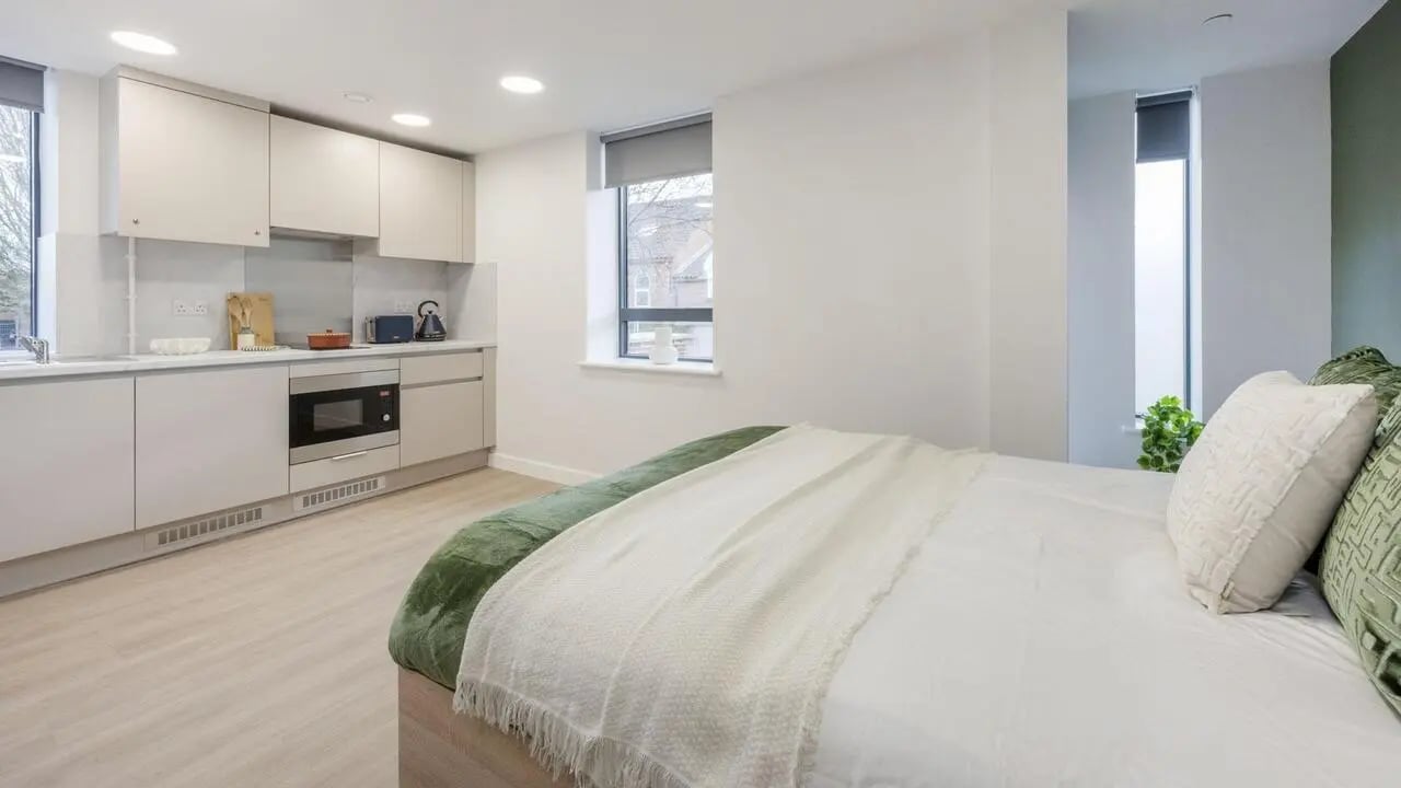 Bed kitchen cabinets microwave white bedding bedroom at Waterloo House in York Student Accommodation