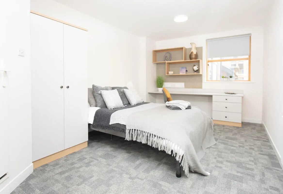 Bed wardrobe desk and shelves bedroom at Abode York in York Student Accommodation