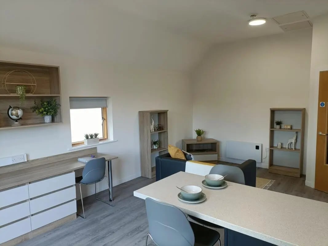 Desk chairs shelving and modern living area Living room at Abode York in York Student Accommodation