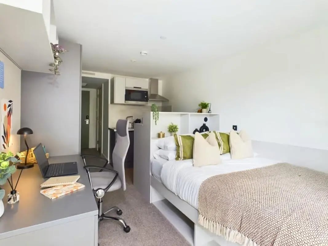 Bed desk chair small kitchen and bed bedroom at The Edge in Belfast Student Accommodation